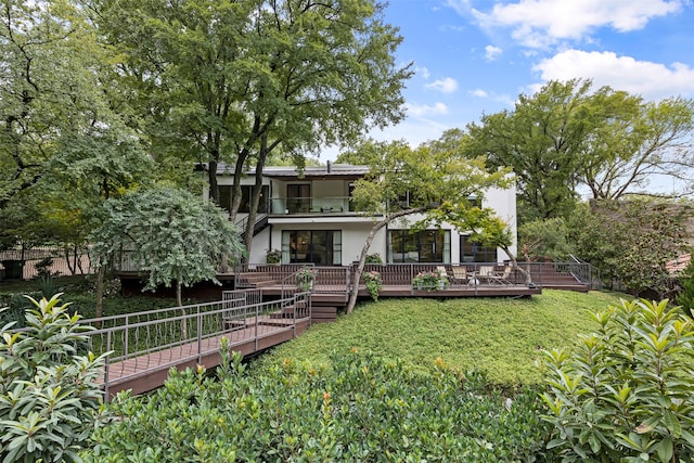 rear view of house with a deck and a yard