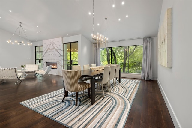 dining room with a high end fireplace, dark hardwood / wood-style flooring, and high vaulted ceiling