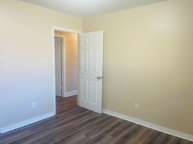 unfurnished room featuring dark hardwood / wood-style flooring