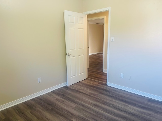 unfurnished room with dark wood-type flooring