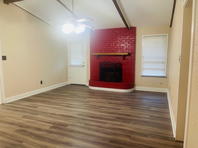 unfurnished living room featuring a brick fireplace, ceiling fan, dark hardwood / wood-style flooring, and lofted ceiling with beams