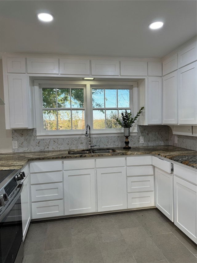 kitchen featuring white cabinets, plenty of natural light, sink, and stainless steel range oven