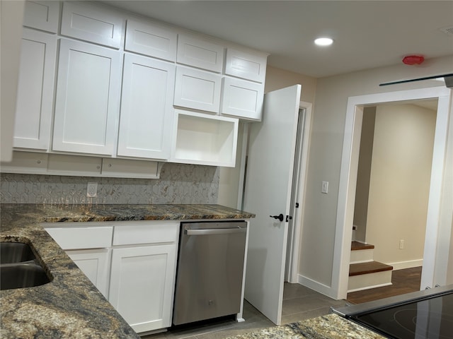 kitchen featuring dishwasher, white cabinetry, tasteful backsplash, and dark stone countertops