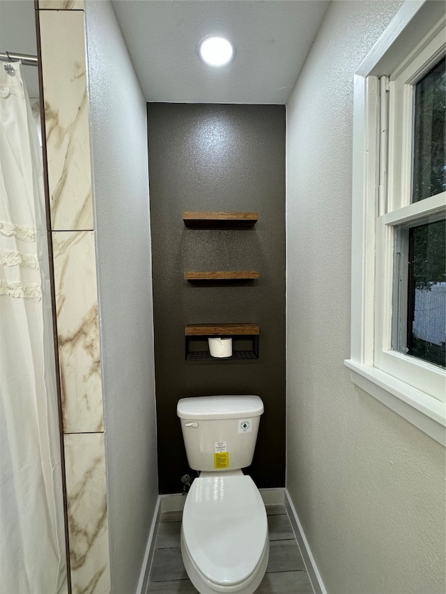 bathroom with toilet and a shower with shower curtain