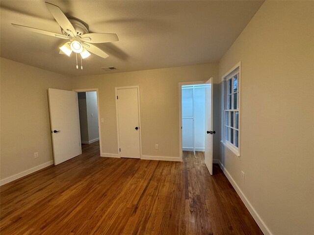 unfurnished bedroom featuring ceiling fan, a closet, and dark hardwood / wood-style flooring