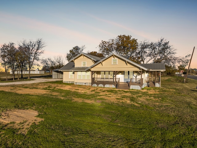 view of front of property featuring covered porch and a yard