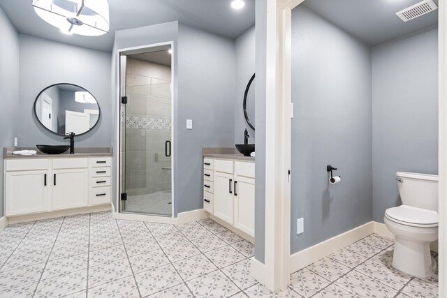 bathroom featuring toilet, vanity, tile patterned floors, and walk in shower