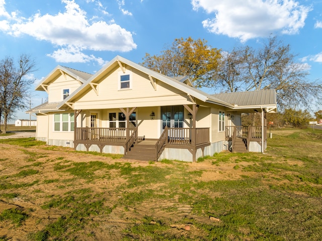 back of property with covered porch and a yard