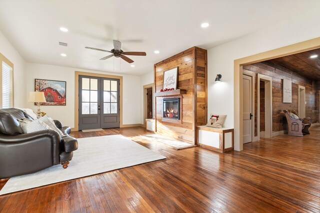 living room featuring a fireplace, hardwood / wood-style flooring, ceiling fan, and french doors