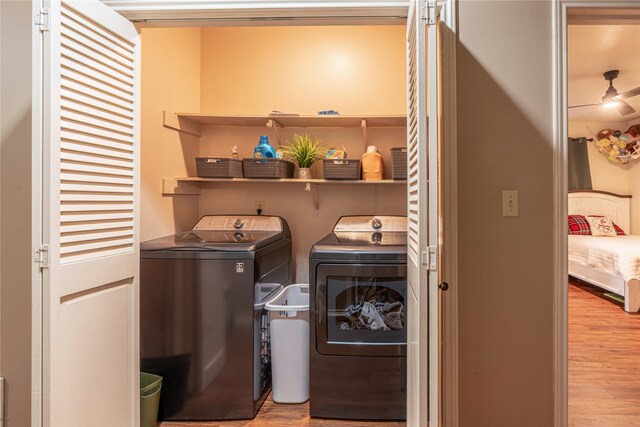 laundry room with light hardwood / wood-style floors and washing machine and dryer