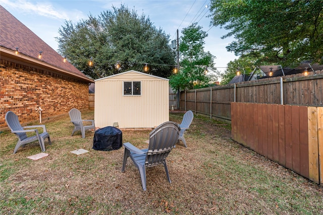 view of yard featuring a shed and an outdoor fire pit