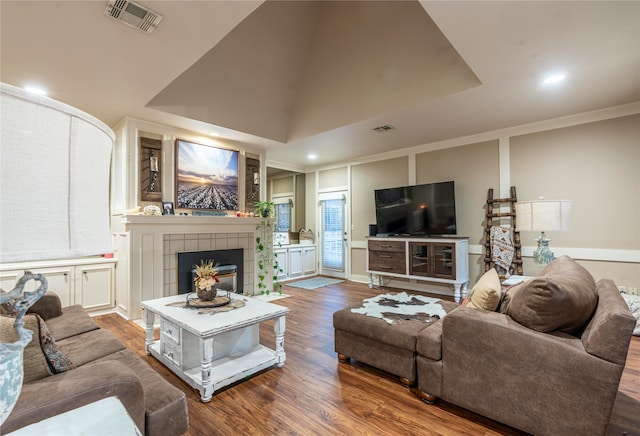 living room featuring a fireplace, dark wood-type flooring, crown molding, and lofted ceiling