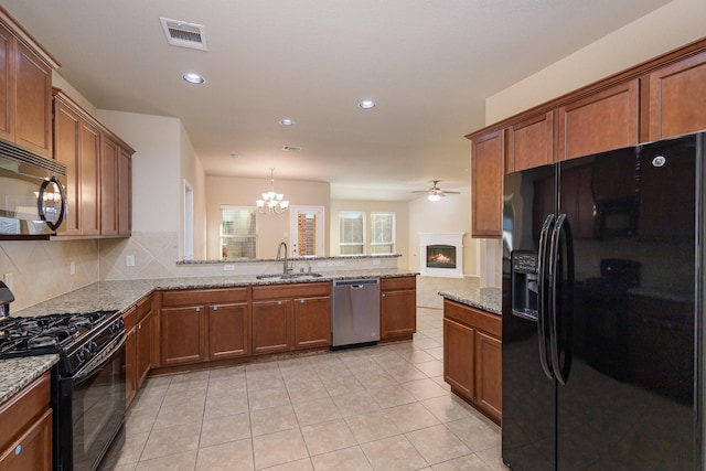 kitchen featuring sink, tasteful backsplash, kitchen peninsula, black appliances, and ceiling fan with notable chandelier