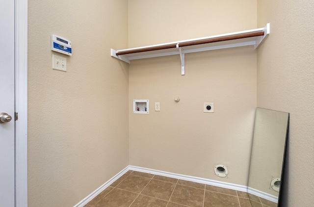 laundry area with gas dryer hookup, hookup for a washing machine, dark tile patterned flooring, and hookup for an electric dryer