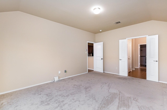 unfurnished bedroom featuring carpet and vaulted ceiling