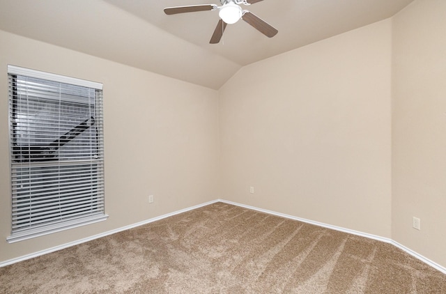 carpeted spare room with vaulted ceiling and ceiling fan