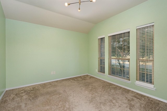 unfurnished room with carpet flooring, vaulted ceiling, and a notable chandelier