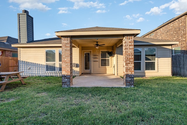 rear view of property with ceiling fan, a yard, and a patio