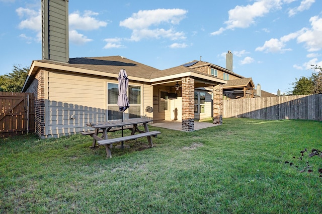 back of house featuring a patio and a lawn