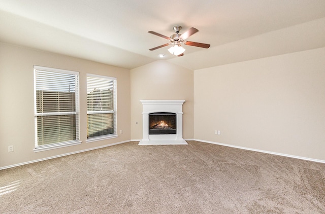 unfurnished living room with ceiling fan, carpet floors, and vaulted ceiling