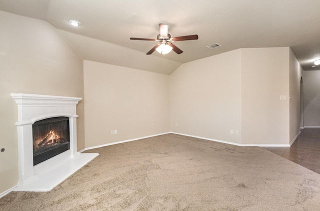 unfurnished living room with dark colored carpet, ceiling fan, and lofted ceiling