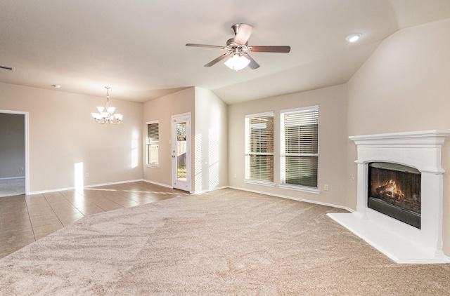 unfurnished living room featuring ceiling fan with notable chandelier, carpet floors, and vaulted ceiling