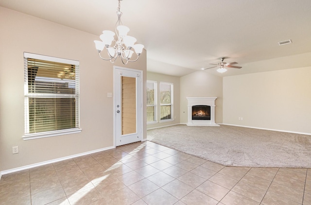 unfurnished living room featuring ceiling fan with notable chandelier and light tile patterned floors