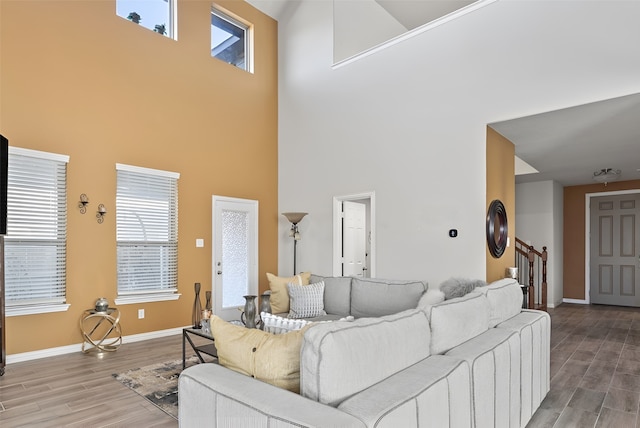 living room with a towering ceiling and hardwood / wood-style floors