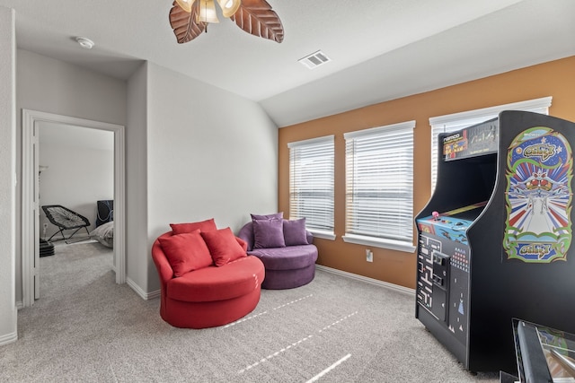 sitting room with lofted ceiling, light carpet, and ceiling fan