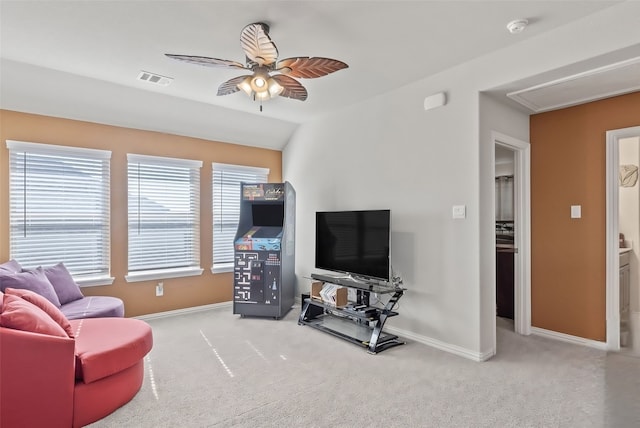 carpeted living room with ceiling fan and vaulted ceiling