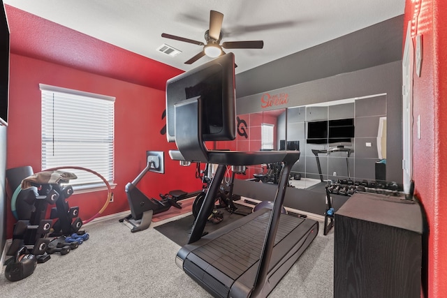 workout area featuring a textured ceiling, carpet, and ceiling fan