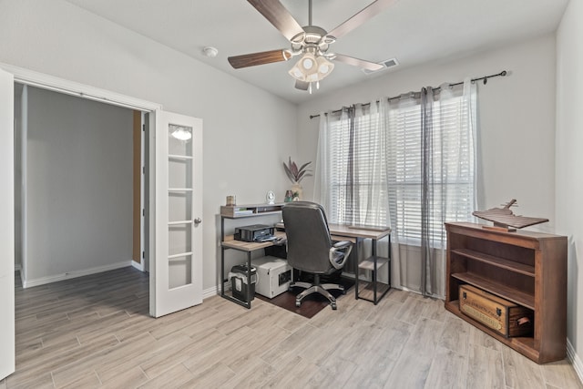 office with light wood-type flooring and ceiling fan