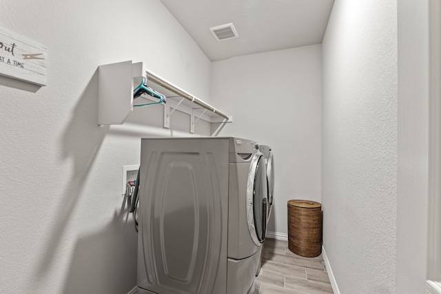 washroom featuring light hardwood / wood-style flooring and independent washer and dryer