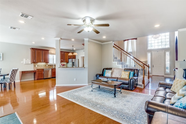 living room featuring ornamental molding, ceiling fan, and light hardwood / wood-style flooring