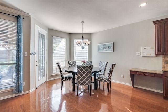 dining area featuring hardwood / wood-style flooring and an inviting chandelier