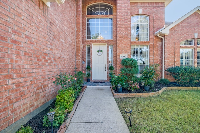 view of exterior entry with a lawn