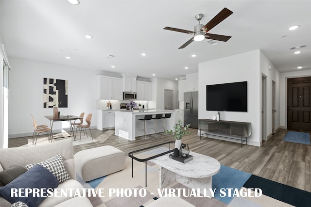 living room featuring light wood-type flooring and ceiling fan