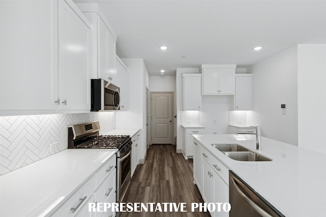 kitchen with dark hardwood / wood-style flooring, white cabinetry, appliances with stainless steel finishes, and sink