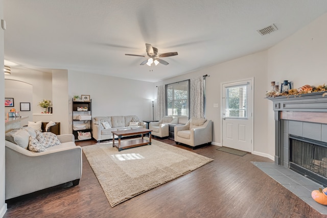 living room with a fireplace, ceiling fan, and dark hardwood / wood-style flooring