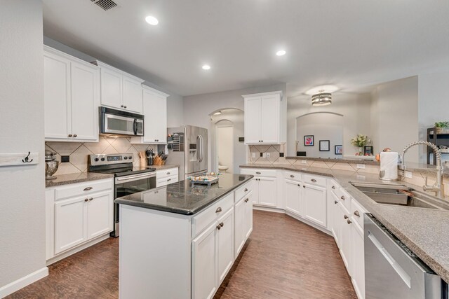 kitchen with a center island, sink, stainless steel appliances, dark hardwood / wood-style floors, and white cabinets