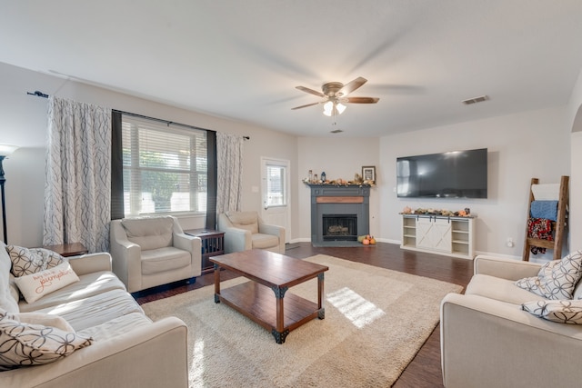 living room with ceiling fan and dark wood-type flooring