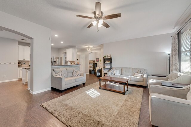 living room with ceiling fan and dark hardwood / wood-style floors