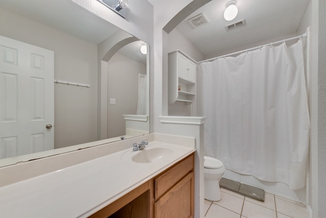 bathroom featuring tile patterned flooring, a shower with curtain, vanity, and toilet