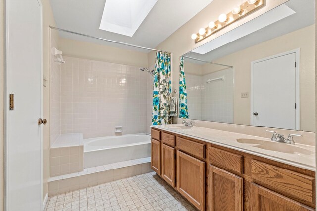 bathroom with a skylight, shower / tub combo with curtain, vanity, and tile patterned floors