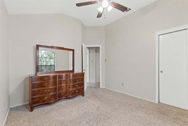 bedroom with a closet, vaulted ceiling, light colored carpet, and ceiling fan