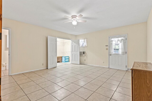 interior space with light tile patterned flooring, ceiling fan, and a wall mounted AC