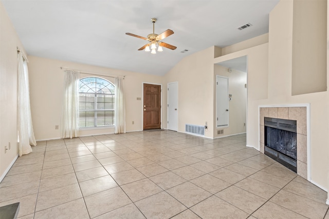 unfurnished living room featuring ceiling fan, lofted ceiling, light tile patterned flooring, and a fireplace