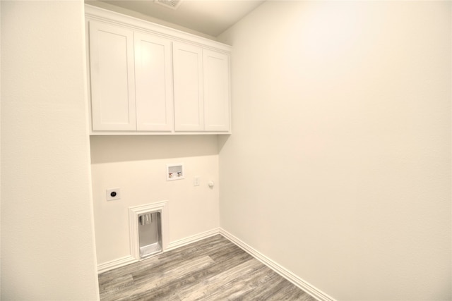 washroom featuring hardwood / wood-style floors, cabinets, hookup for a gas dryer, washer hookup, and hookup for an electric dryer