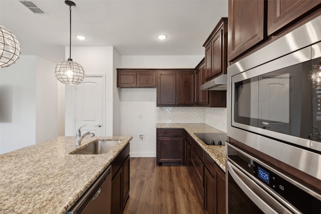 kitchen with dark wood-type flooring, sink, light stone counters, and appliances with stainless steel finishes