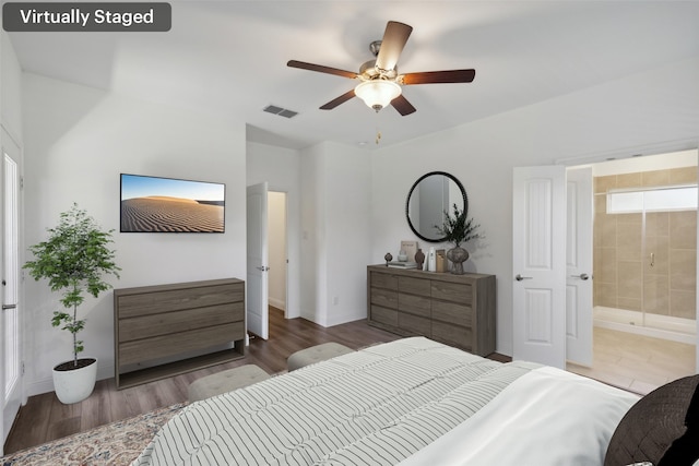 bedroom featuring ensuite bath, dark wood-type flooring, and ceiling fan